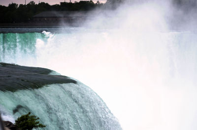 Scenic view of waterfall against sky