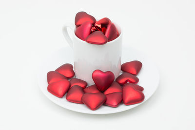 Close-up of red berries over white background