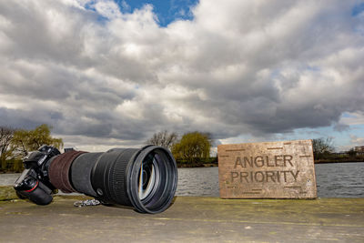 Reflection of camera on water against sky