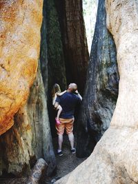 Rear view of man climbing on rock