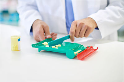 Midsection of man playing with toy blocks on white background