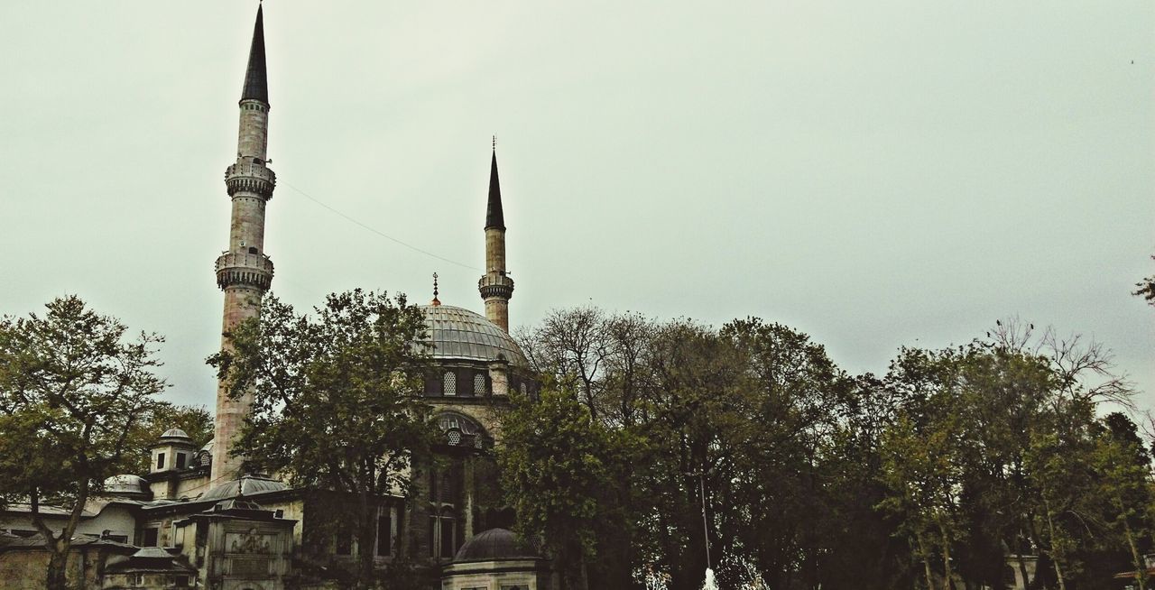 architecture, building exterior, built structure, religion, place of worship, clear sky, tree, low angle view, church, spirituality, tower, copy space, steeple, dome, spire, sky, cross