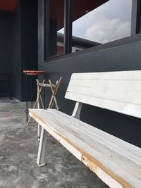 Empty bench on table against building