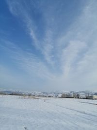 Snow covered field against sky