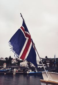 Low angle view of flag on boat against sky