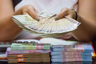 Midsection of woman holding paper currencies