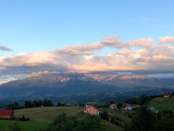 Scenic view of landscape and houses against sky