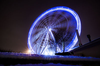 Low angle view of illuminated ferris wheel against sky at night