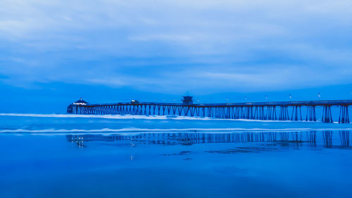 View of bridge over sea against cloudy sky