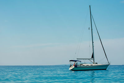 Sailboat sailing in sea against sky