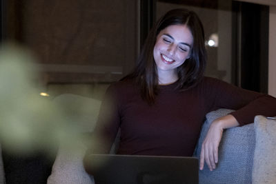 Portrait of young woman sitting at home