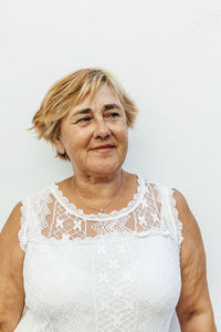 Portrait of a senior woman with a white wall background