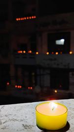 Close-up of illuminated tea light candles on table