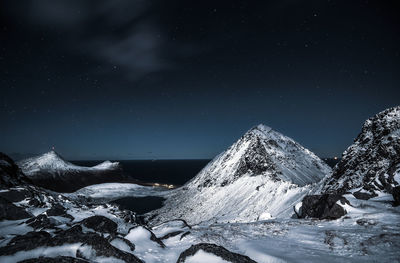 Scenic view of snowcapped mountains against sky at night