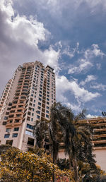 Low angle view of buildings against cloudy sky