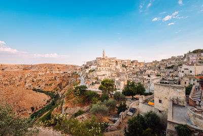 Wide view of the sassi di matera from the belvedere colombo blue sky with clouds