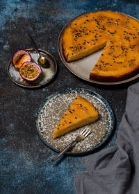  fresh baked mango upside down cake with passion fruit and a piece cut off on a plate.