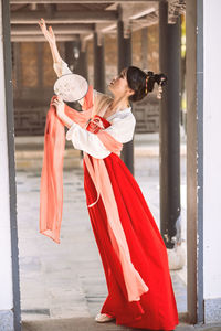 Side view of woman standing with umbrella