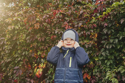 Portrait of a boy in cold autumn weather against the background of autumn foliage. autumn colors. 