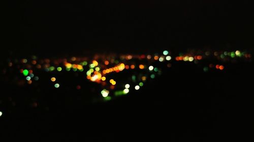 Defocused lights against sky at night