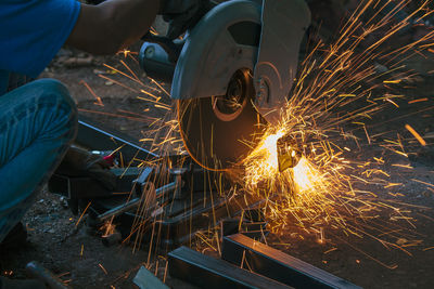 Cropped image of male worker cutting metal in factory
