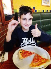 Portrait of happy boy sitting on plate