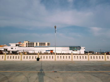 Buildings by street against sky in city