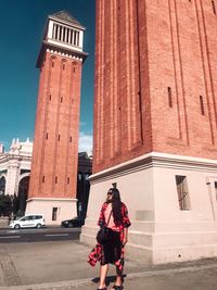 Woman standing by building in city