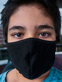 Close-up portrait of teenage girl covering face