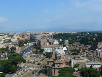 Mid distance view of coliseum with cityscape against sky