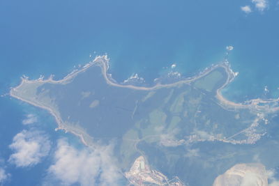 Aerial view of sea against blue sky