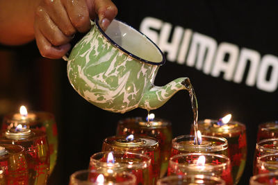 Close-up of hand holding candles