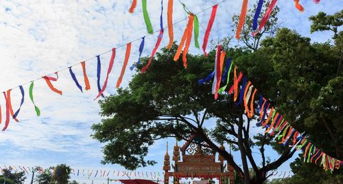 Low angle view of flags hanging against trees