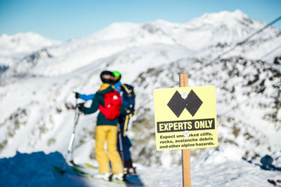 Information sign on snow covered mountain