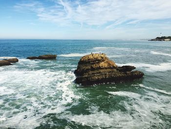 Scenic view of rocks in sea against sky