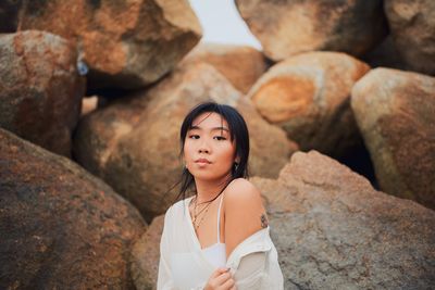 Portrait of young woman against rocks