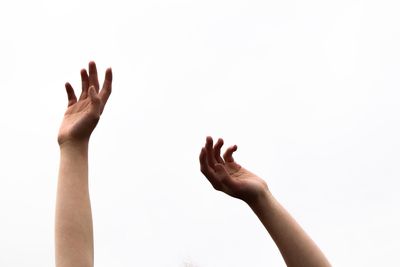 Cropped hands of people against white background