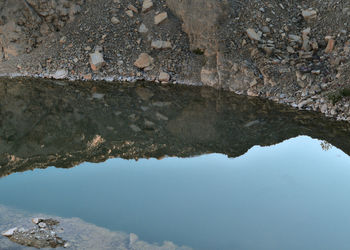 Reflection of rock formation in lake against sky