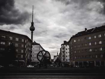 Buildings in city against cloudy sky