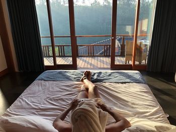 High angle view of man relaxing on bed in hotel