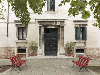 Empty chairs and tables against building