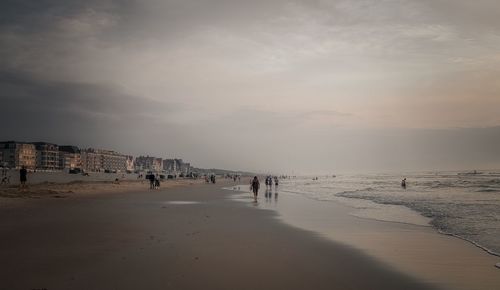 Group of people on beach against sky