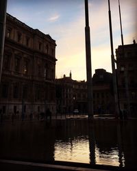 Reflection of buildings in water at sunset