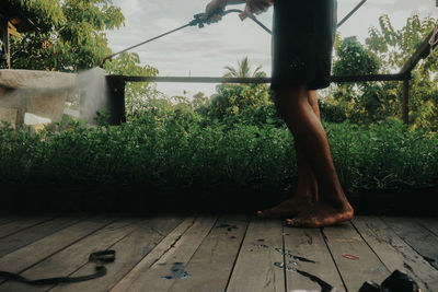 Low section of person standing on wooden floor