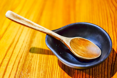 Close-up of bowl with spoon on wooden table