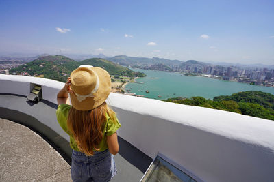 Rear view of traveler woman enjoying landscape of vitoria metropolitan region espirito santo, brazil