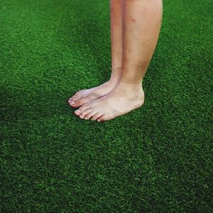 Low section of woman standing on field