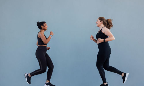 Full length of young woman exercising in gym