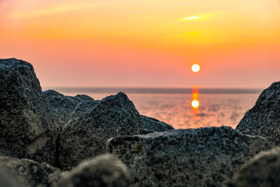 Scenic view of sea against orange sky