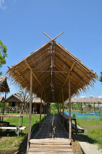 Traditional windmill on field against clear blue sky